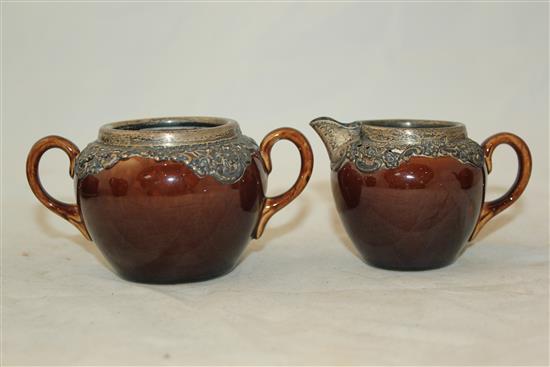 Wedgwood treacle glazed pottery silver mounted part tea set, c.1906, the hot water pot 13cm., one plate broken (13)(-)